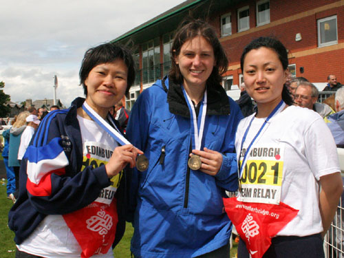 Three female runners show off their medals